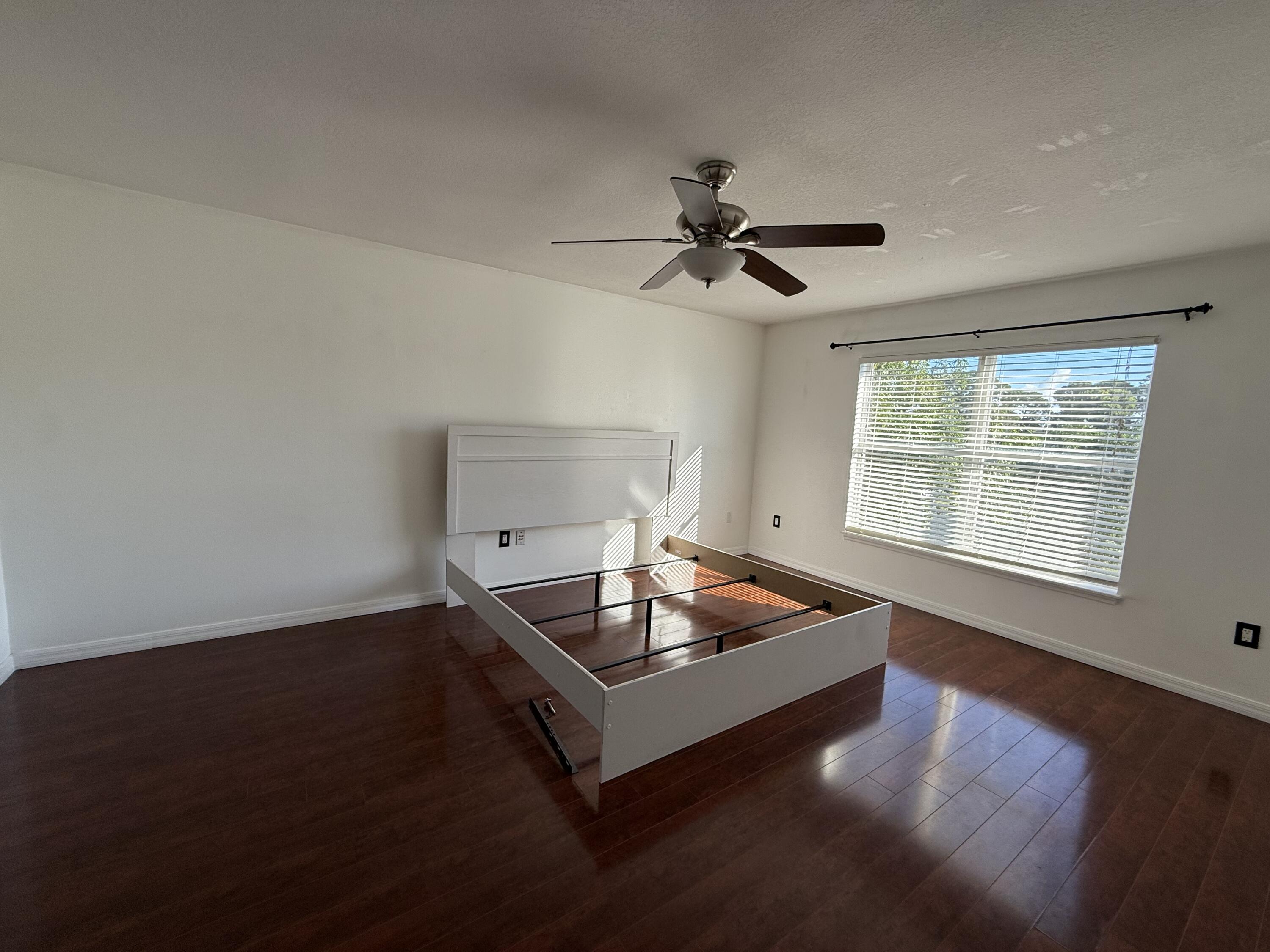 1925 Southwest Libra Lane Port St. Lucie, FL 34984 - Photo 36 of 49 a living room with hard wood floors a ceiling fan and a window