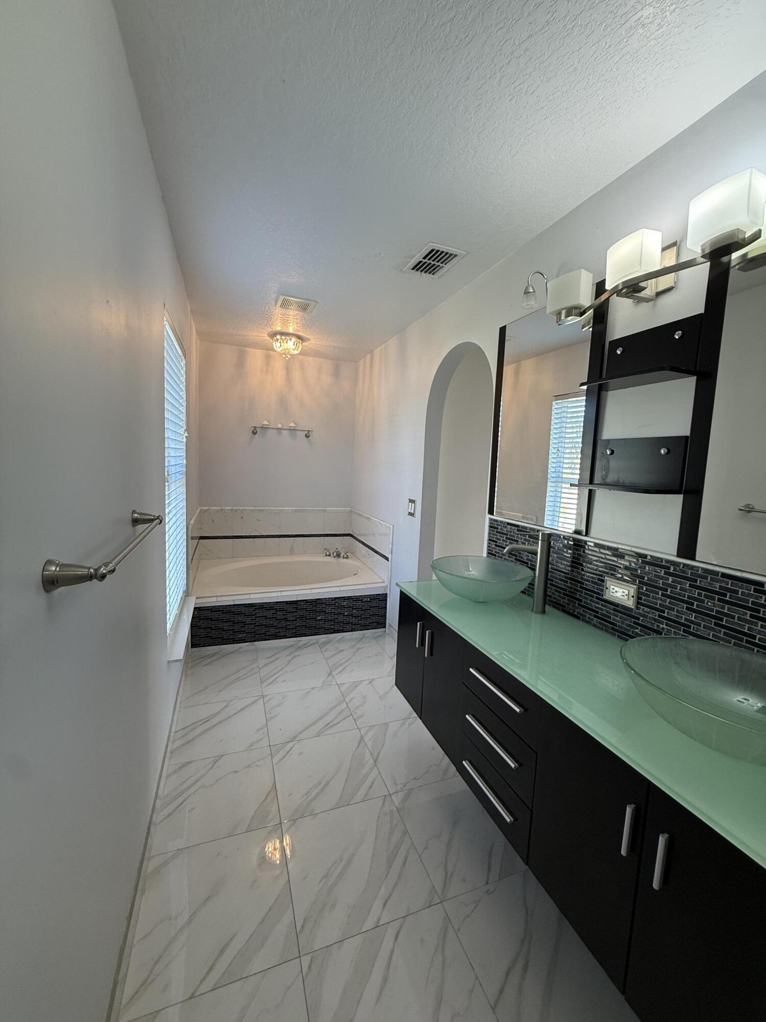 1925 Southwest Libra Lane Port St. Lucie, FL 34984 - Photo 42 of 49 a bathroom with a double vanity sink and a mirror