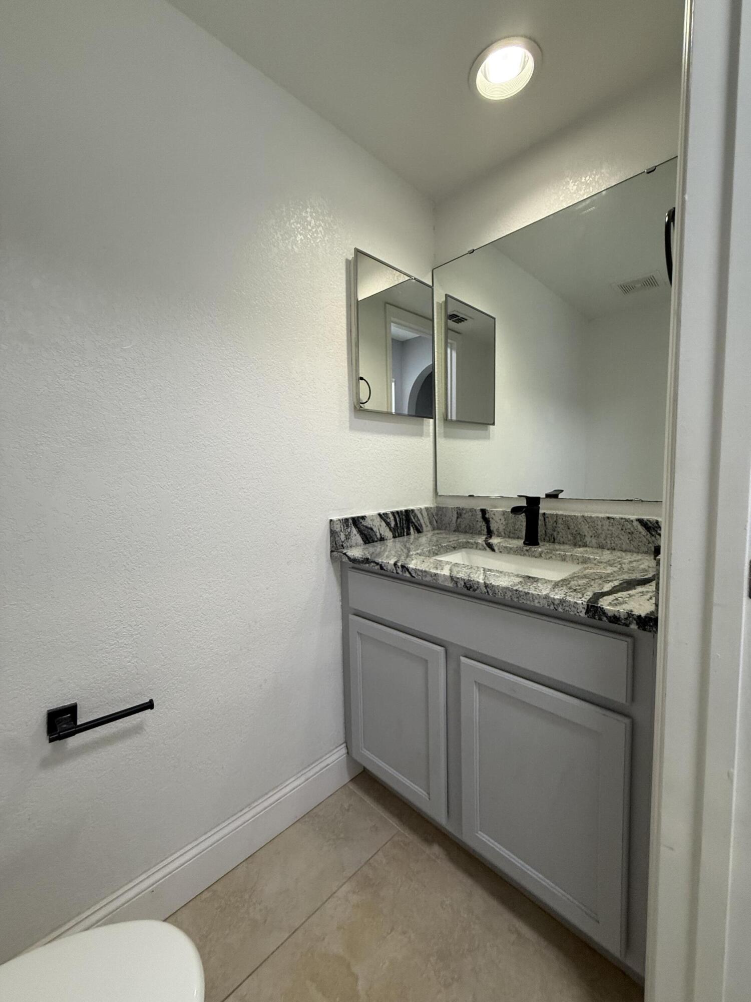 1925 Southwest Libra Lane Port St. Lucie, FL 34984 - Photo 5 of 49 a bathroom with a granite countertop sink and a mirror