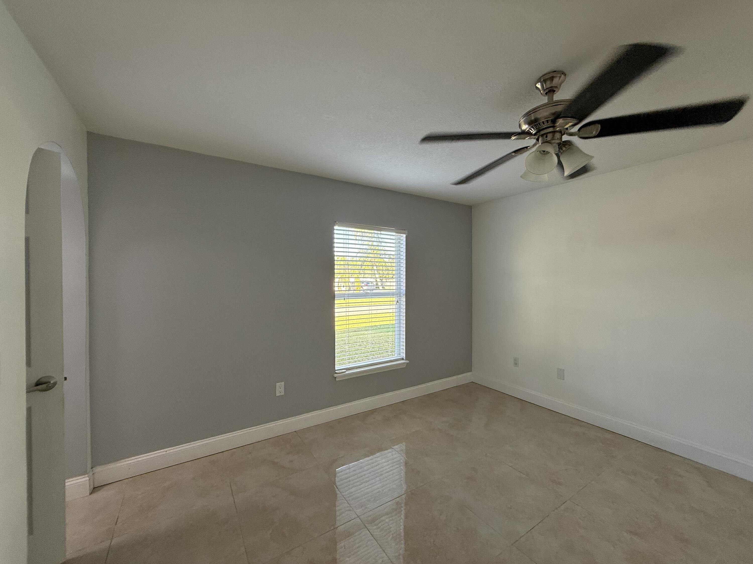 1925 Southwest Libra Lane Port St. Lucie, FL 34984 - Photo 7 of 49 an empty room with windows and fan