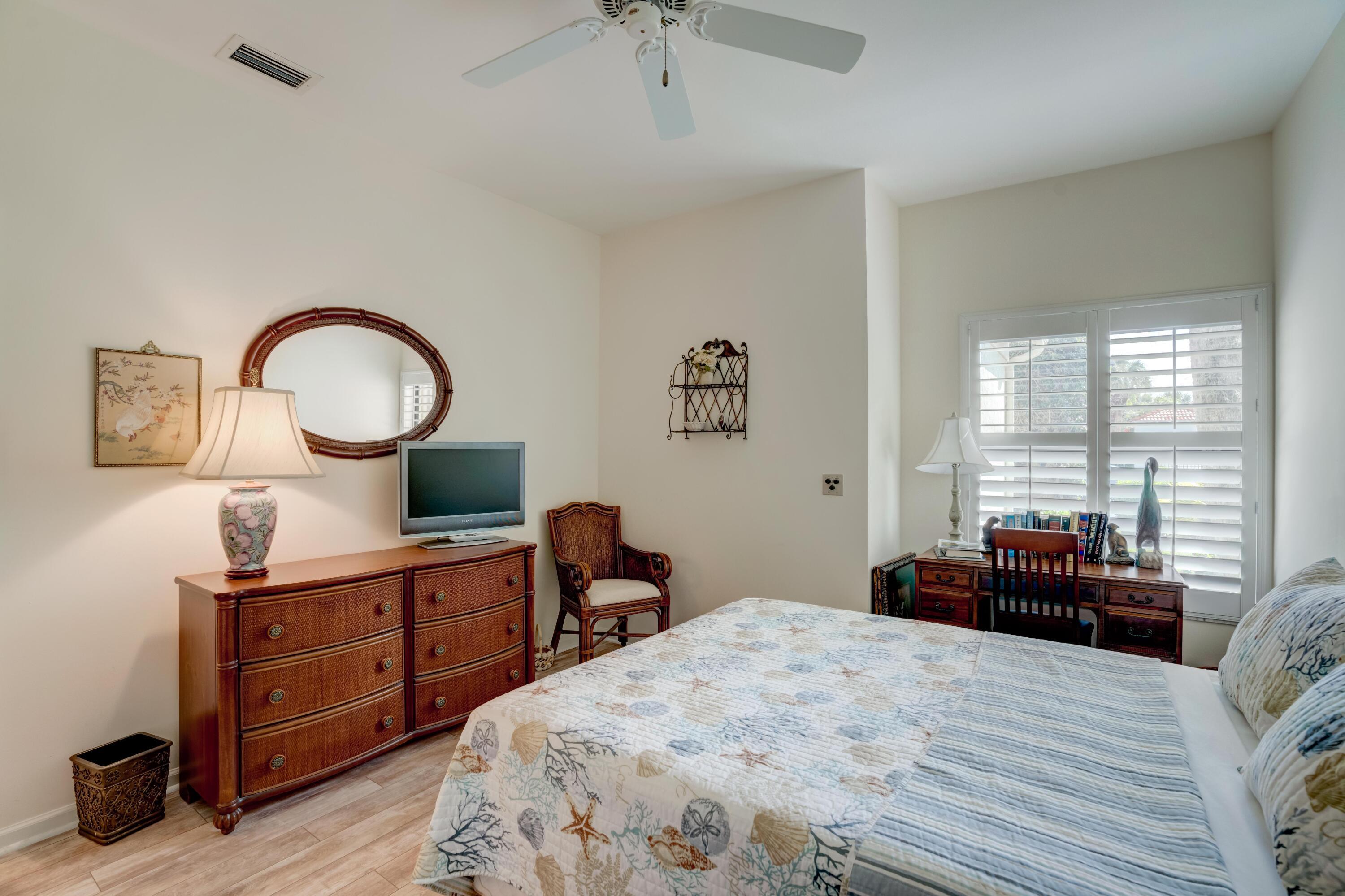 3518 Lantern Bay Drive Jupiter, FL 33477 - Photo 11 of 32 a bedroom with a bed and a chandelier