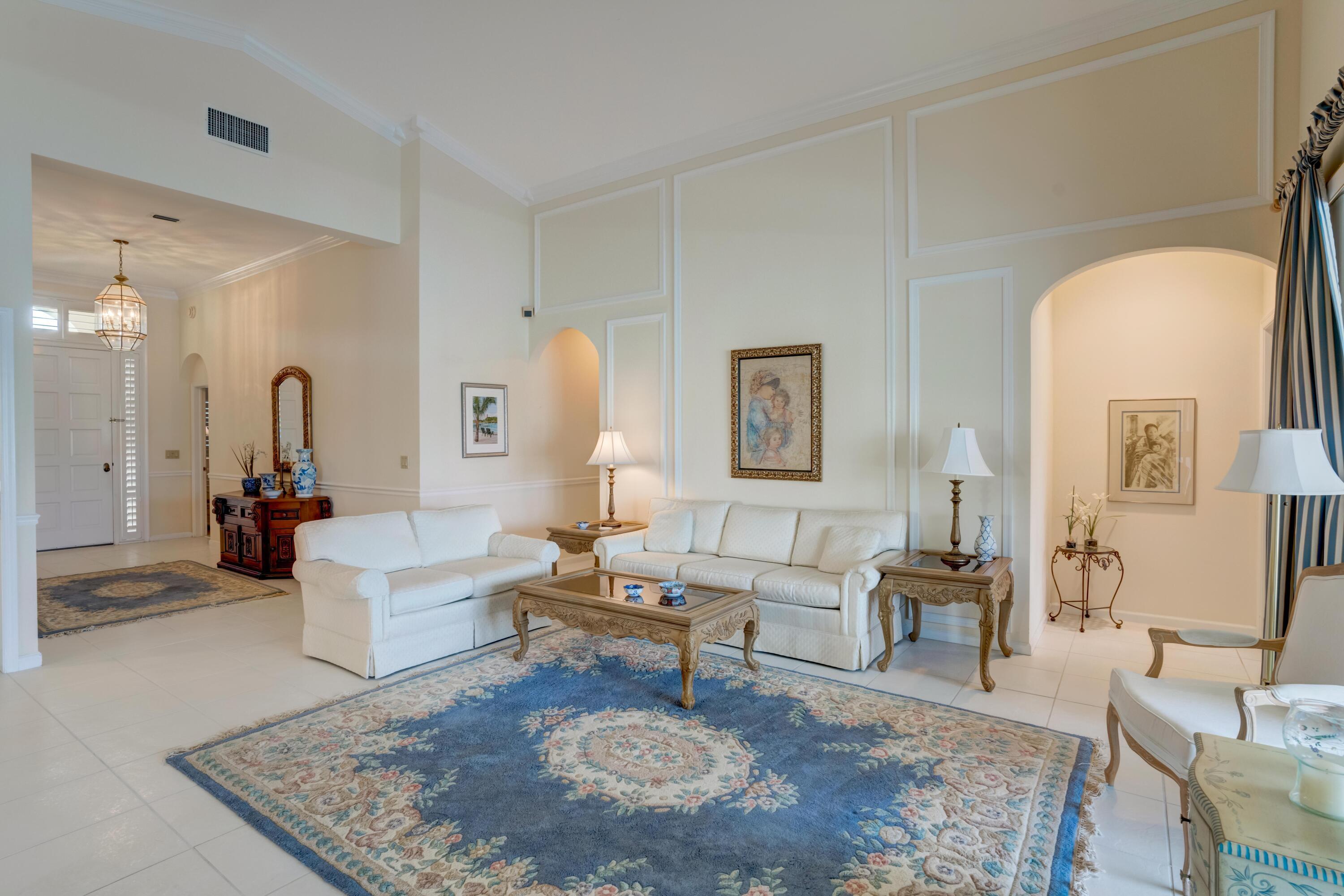 3518 Lantern Bay Drive Jupiter, FL 33477 - Photo 14 of 32 a living room with furniture a rug a lamp and a table