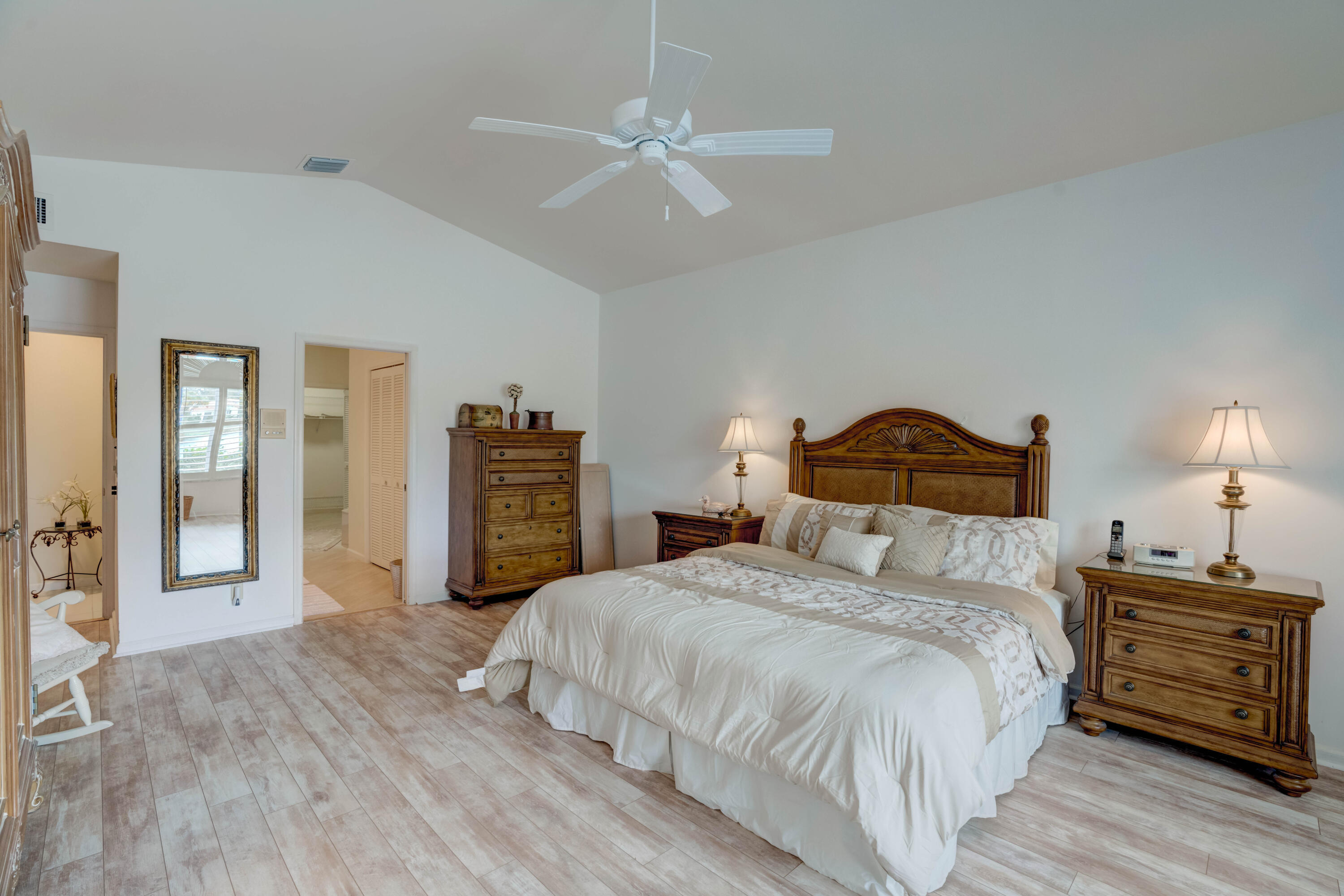 3518 Lantern Bay Drive Jupiter, FL 33477 - Photo 18 of 32 a bedroom with a bed and a chandelier