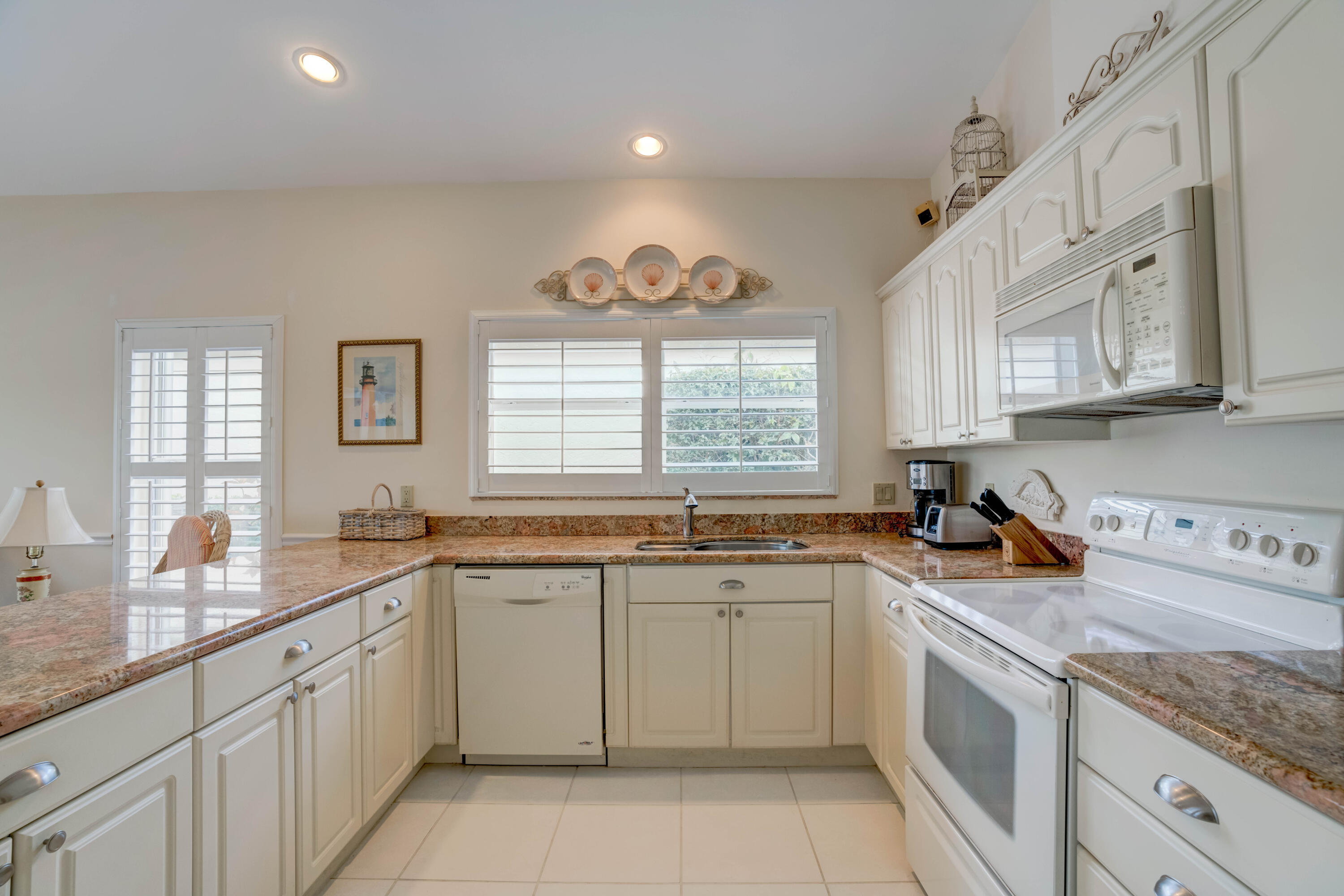 3518 Lantern Bay Drive Jupiter, FL 33477 - Photo 25 of 32 a kitchen with a sink window and cabinets
