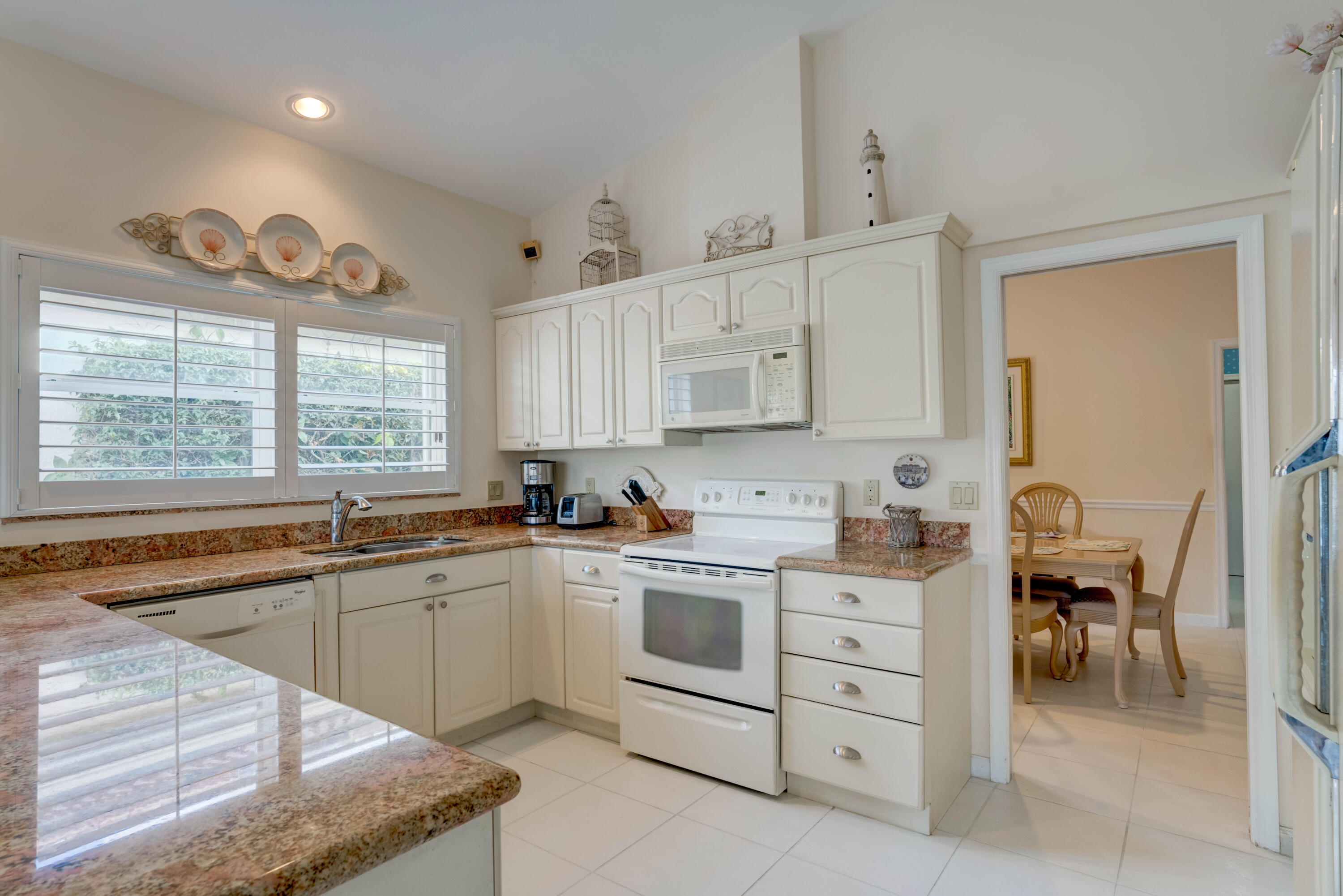 3518 Lantern Bay Drive Jupiter, FL 33477 - Photo 26 of 32 a kitchen with cabinets appliances and a window