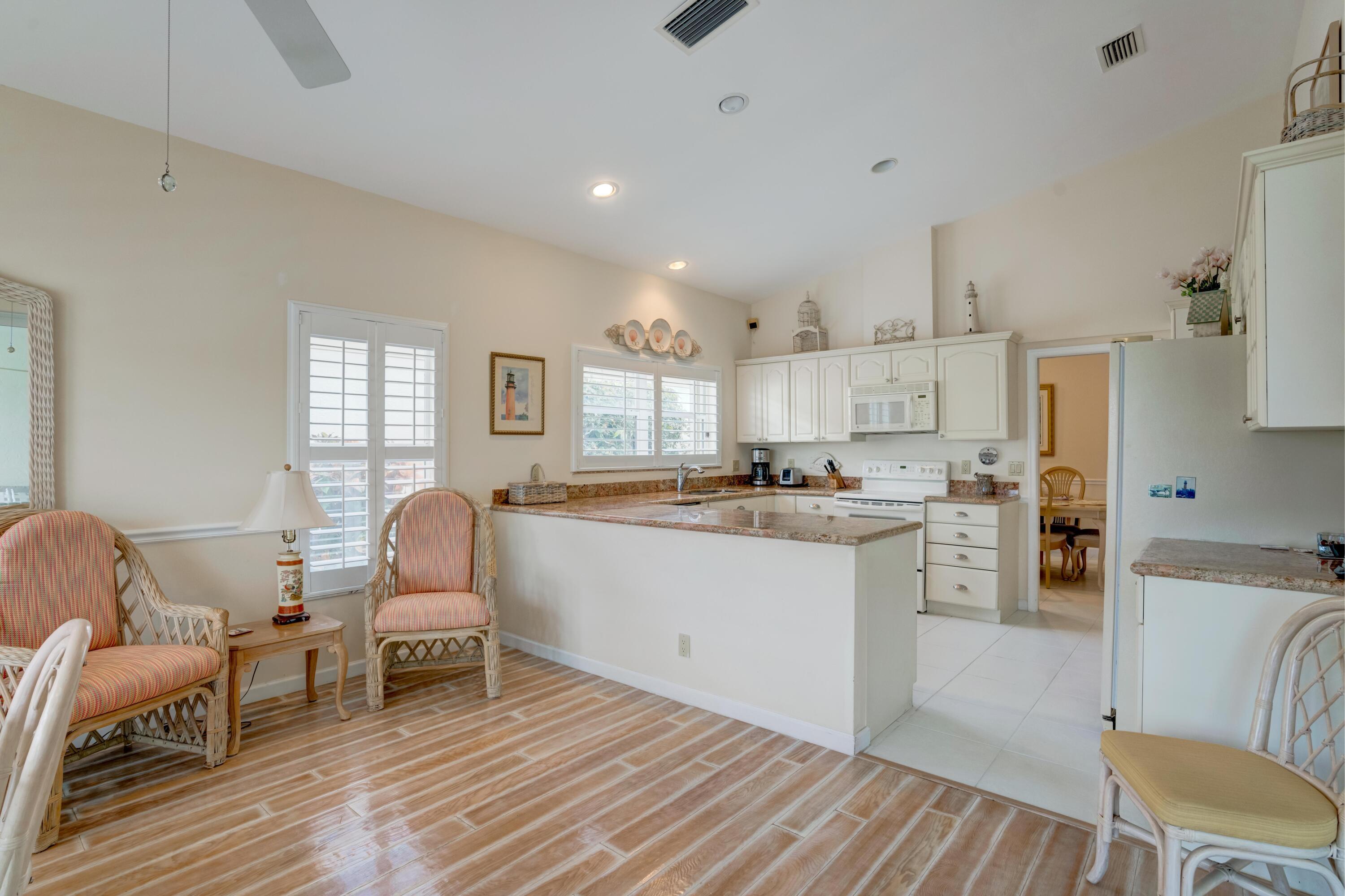 3518 Lantern Bay Drive Jupiter, FL 33477 - Photo 31 of 32 a kitchen with a sink and chairs