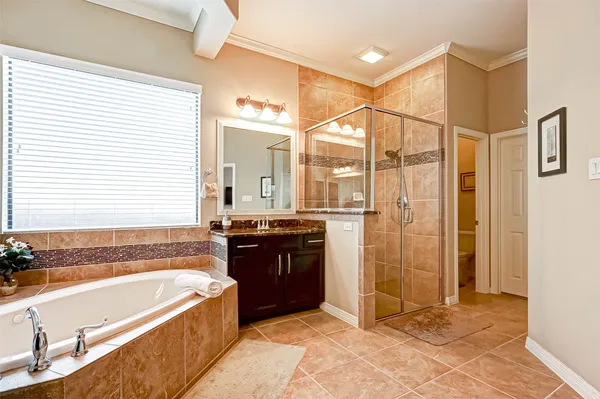 a large bathroom with a granite countertop double vanity and a mirror