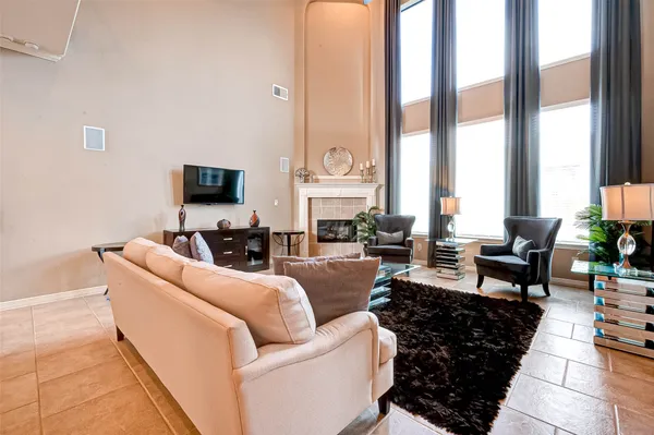 a living room with furniture large window and a fireplace