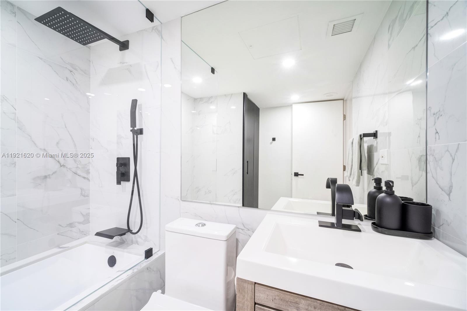 1500 Bay Road, Unit 1558S Miami Beach, FL 33139 - Photo 26 of 54 a bathroom with a tub sink and mirror