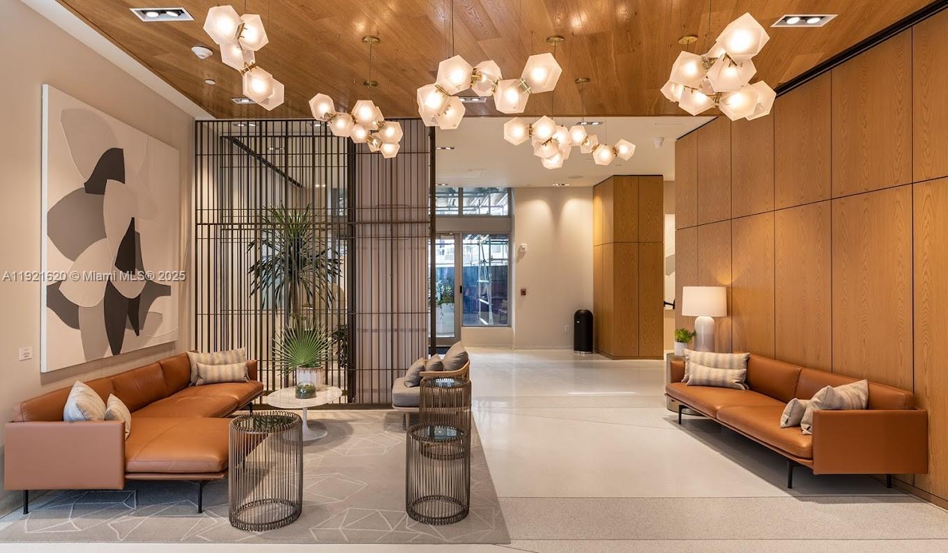 1500 Bay Road, Unit 1558S Miami Beach, FL 33139 - Photo 49 of 54 a living room with furniture a chandelier and a large mirror