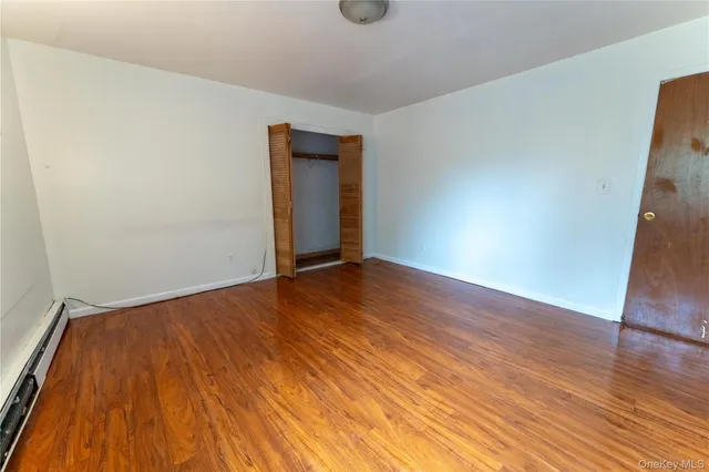 a view of an empty room with wooden floor