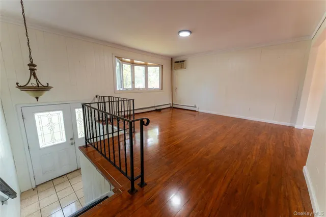 a view of a hallway with wooden floor and stairs