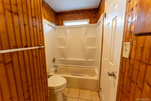a bathroom with a granite countertop shower and a toilet