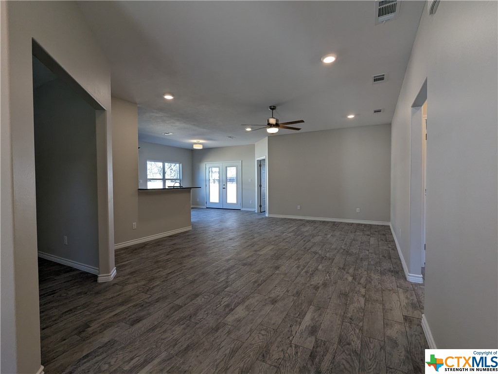 407 Gamel Street Lampasas, TX 76550 - Photo 4 of 20 an empty room with wooden floor and windows