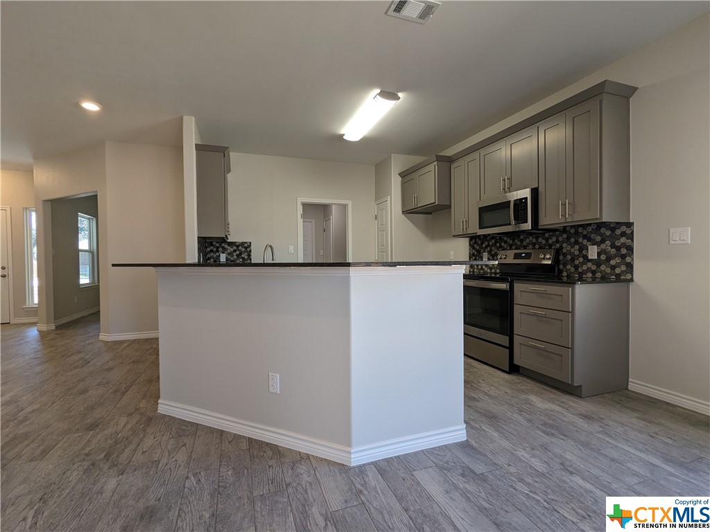 407 Gamel Street Lampasas, TX 76550 - Photo 7 of 20 a kitchen with stainless steel appliances granite countertop a stove a sink and a refrigerator