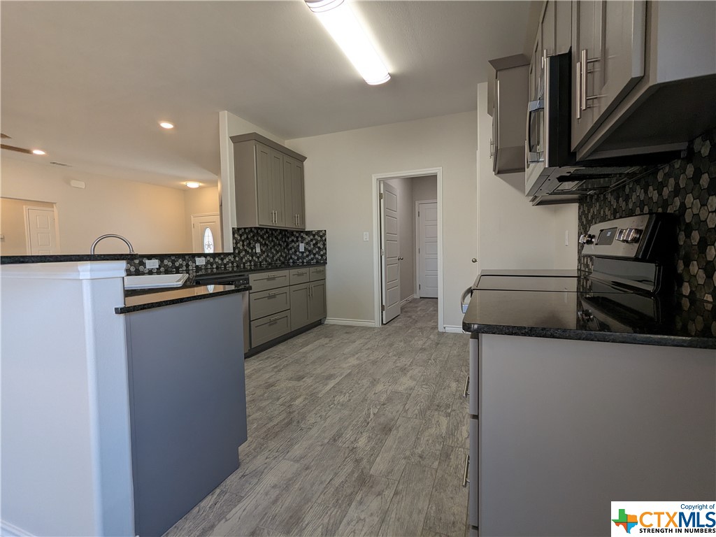 407 Gamel Street Lampasas, TX 76550 - Photo 8 of 20 a kitchen with stainless steel appliances granite countertop a refrigerator and a stove