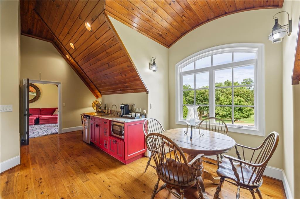 4239 Lower Jersey Road Covington, GA 30014 - Photo 64 of 91 a kitchen with stainless steel appliances granite countertop a stove top oven a dining table and chairs with the outer view