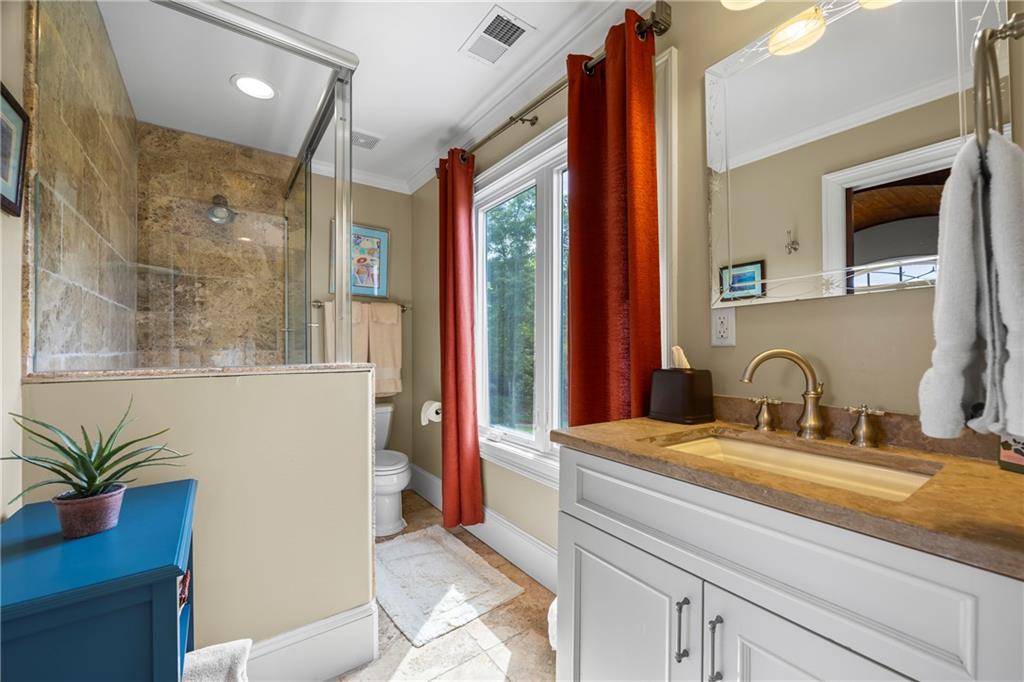 4239 Lower Jersey Road Covington, GA 30014 - Photo 67 of 91 a bathroom with a granite countertop sink a large mirror and a shower