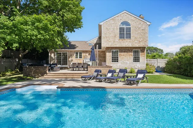 a front view of house with yard and trees in the background