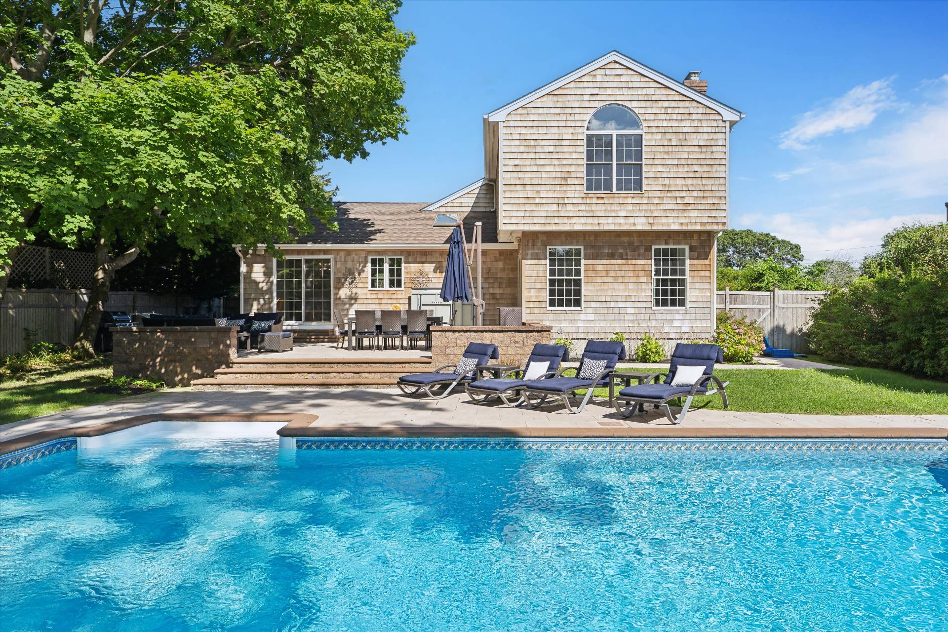 a front view of house with yard and trees in the background