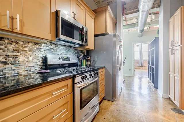 a kitchen with stainless steel appliances granite countertop a stove and a microwave