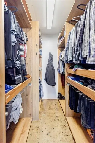 a view of walk in closet with clothes and shoes