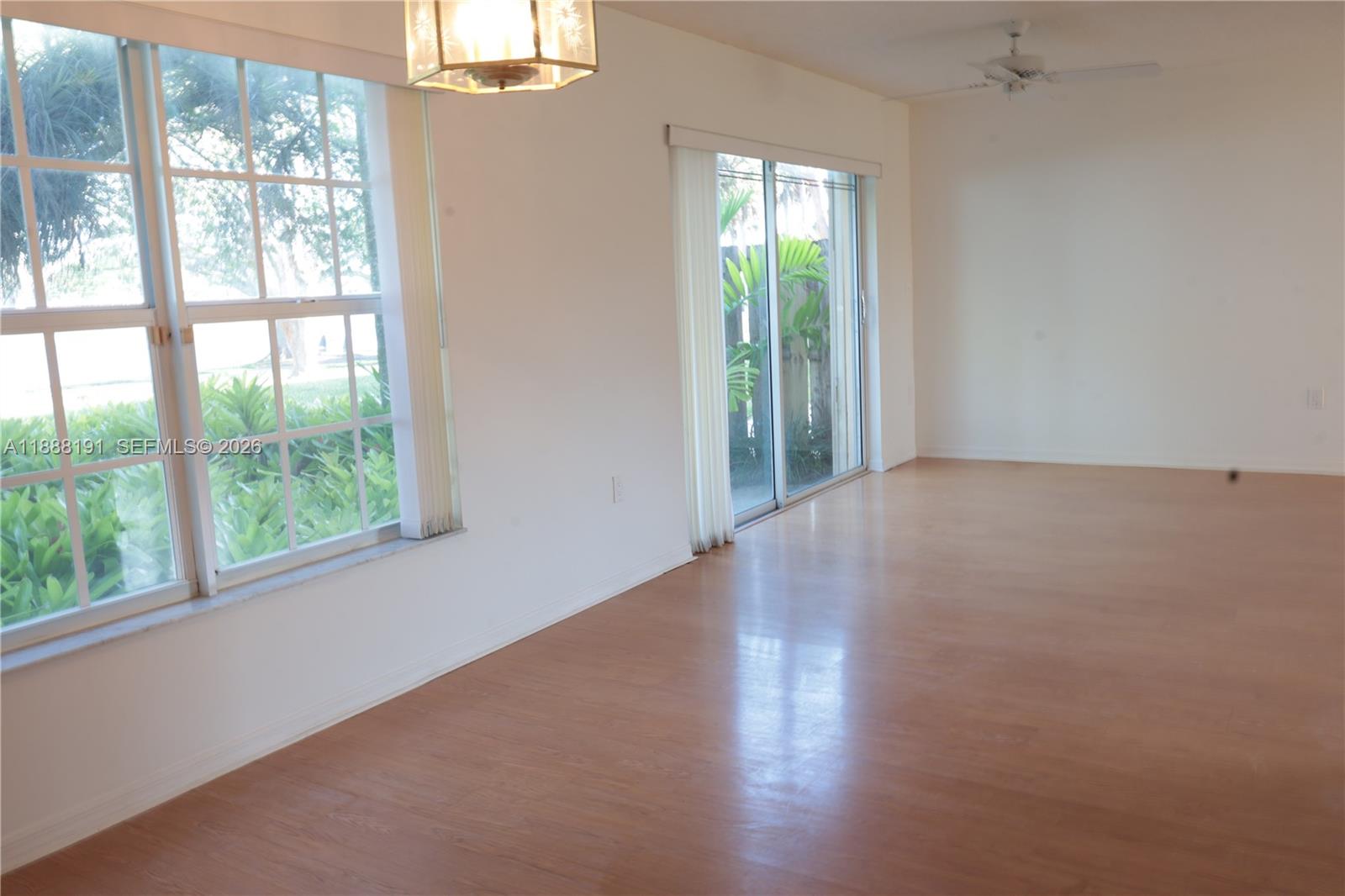 10889 Southwest 149th Place Miami, FL 33196 - Photo 15 of 51 a view of a big room with windows and wooden floor