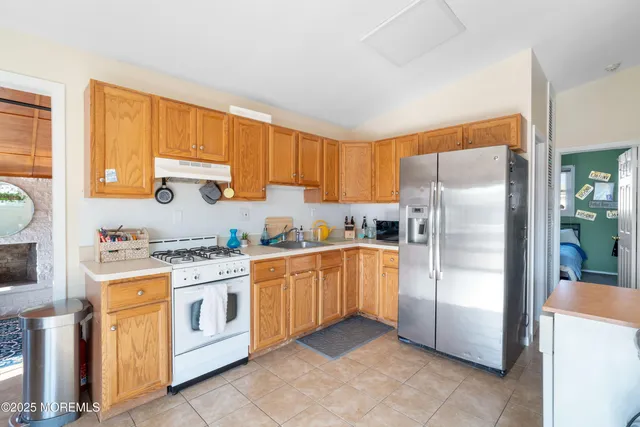 a kitchen with stainless steel appliances granite countertop a refrigerator sink and cabinets