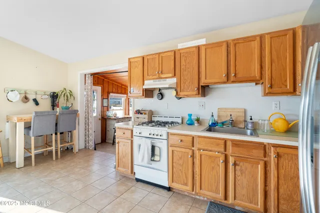 a kitchen with stainless steel appliances granite countertop a stove a sink dishwasher and cabinets with wooden floor