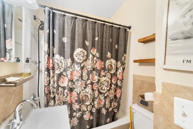 a bathroom with a granite countertop sink and a shower curtain