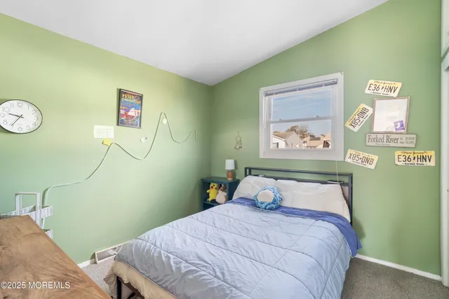 a bedroom with a bed and painting on the wall