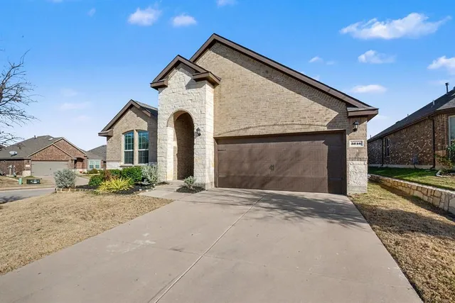 a front view of a house with a yard and garage