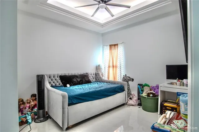 a bedroom with bed a flat screen tv and a window