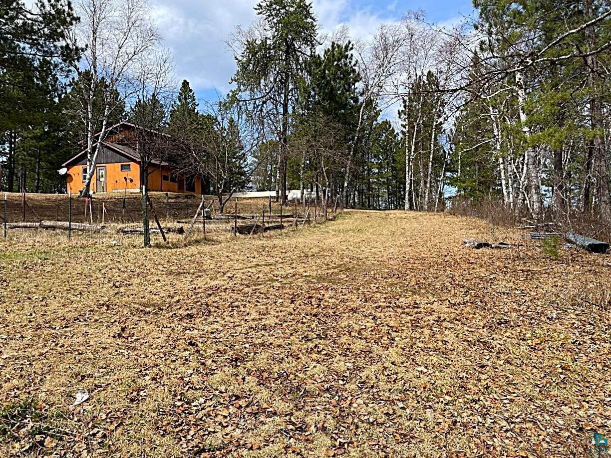 1480 Maijala Road Ely, MN 55731 - Photo 55 of 58 Expansive cleared land parcel bordered by mature trees and a fenced garden area