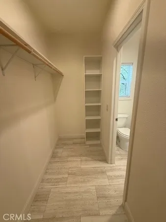 a view of walk in closet with empty racks