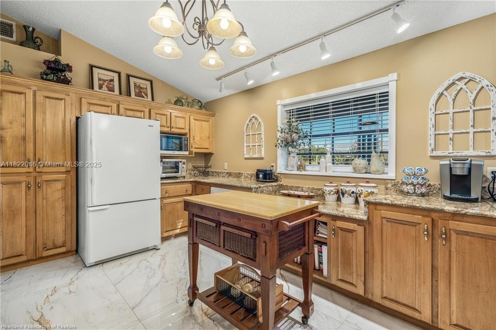 479 E Street Zolfo Springs, FL 33890 - Photo 11 of 50 a kitchen with stainless steel appliances granite countertop a refrigerator a sink dishwasher a stove with white cabinets and wooden floor