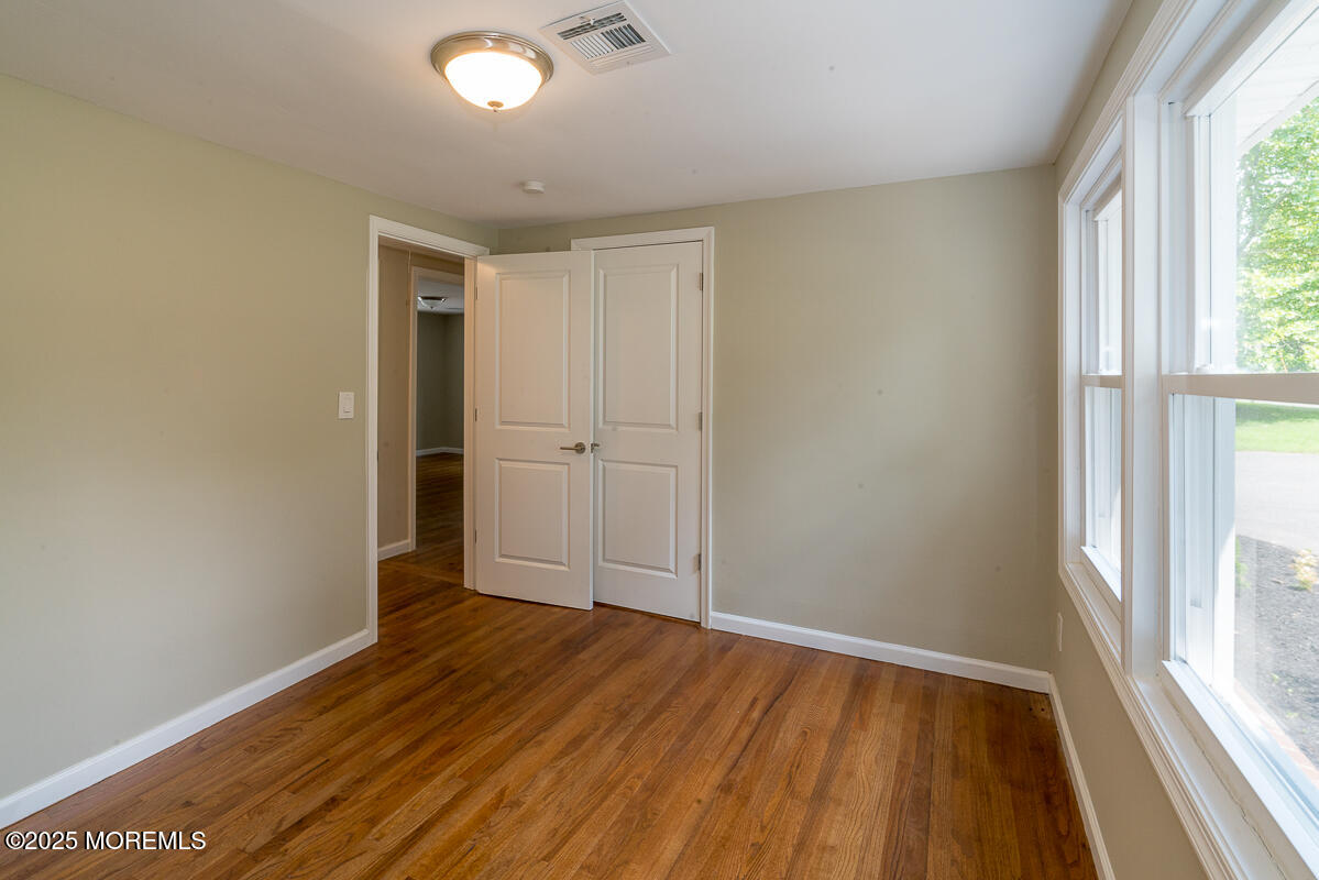 21 Wickatunk Road Manalapan, NJ 07726 - Photo 21 of 48 an empty room with wooden floor and windows