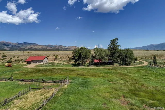 a yard with lots of green space and mountain view in back