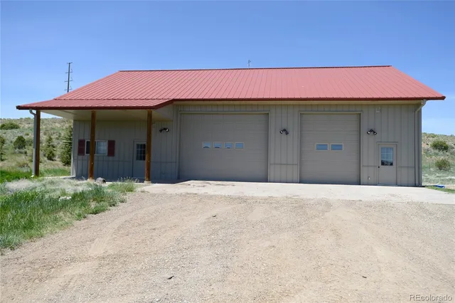 a view of a house with a yard and potted plants