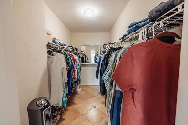 a view of walk in closet with clothes and shoes