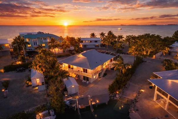 a spacious bedroom with a large bed a chandelier and flat screen tv