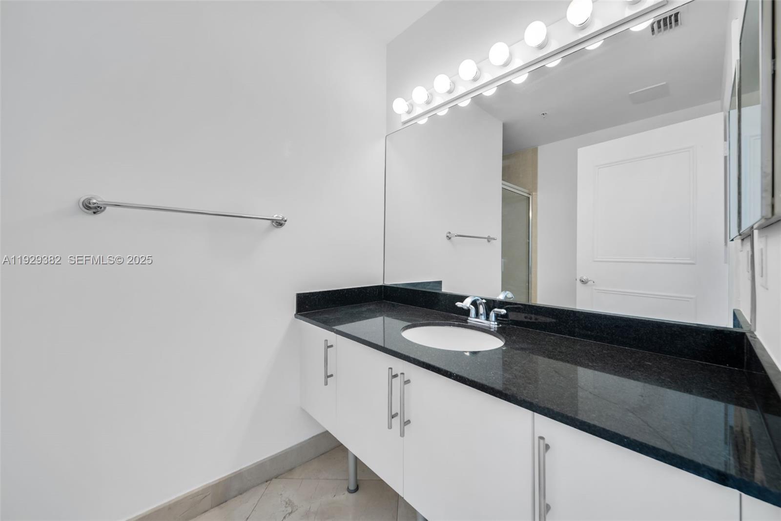 31 Southeast 5th Street, Unit 4314 Miami, FL 33131 - Photo 21 of 40 a bathroom with a granite countertop sink and a mirror