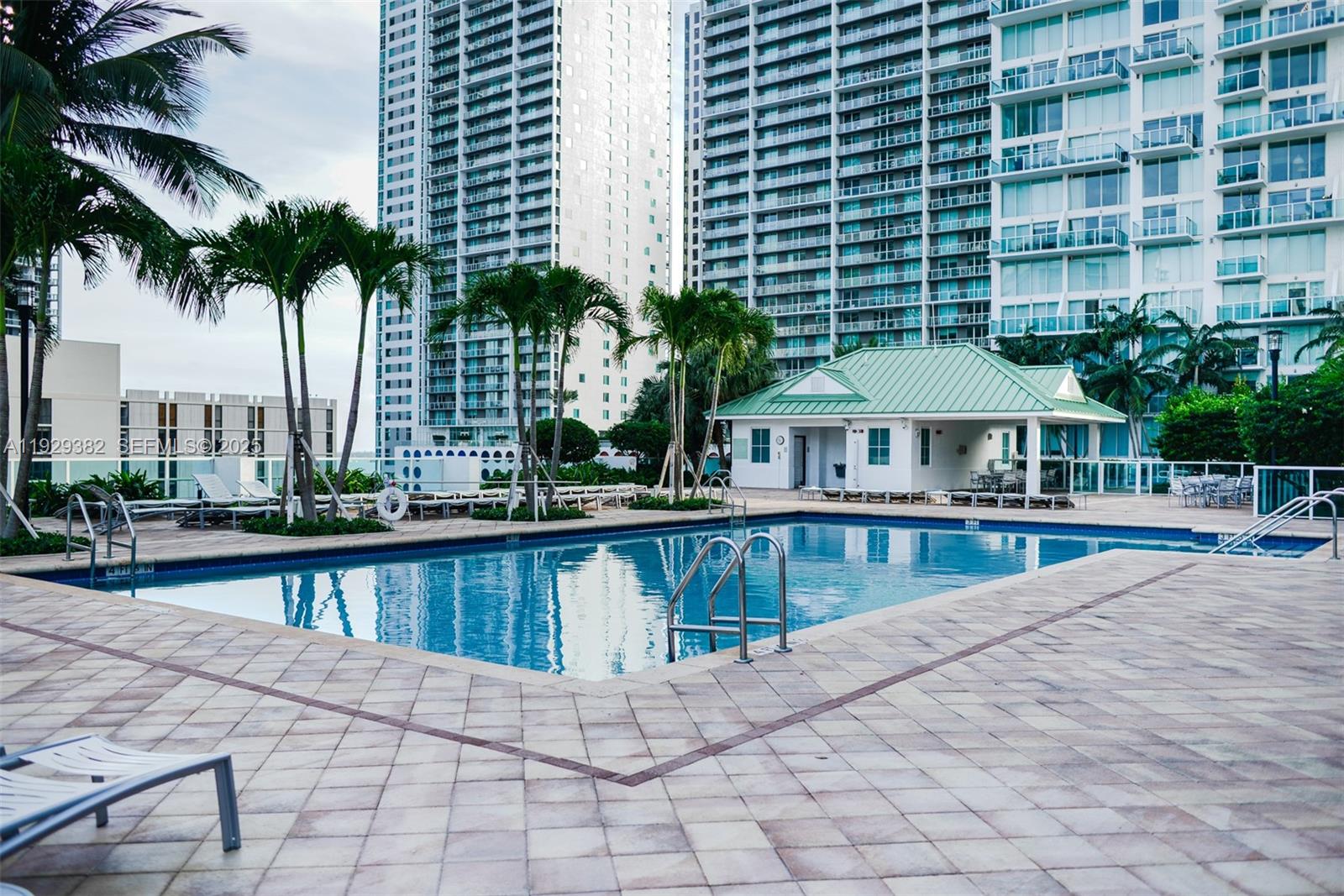 31 Southeast 5th Street, Unit 4314 Miami, FL 33131 - Photo 37 of 40 a view of a swimming pool with a lounge chair and palm trees