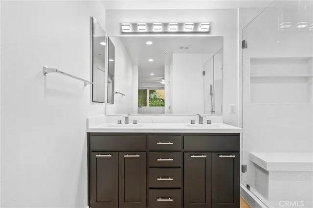 a bathroom with double sink and a mirror