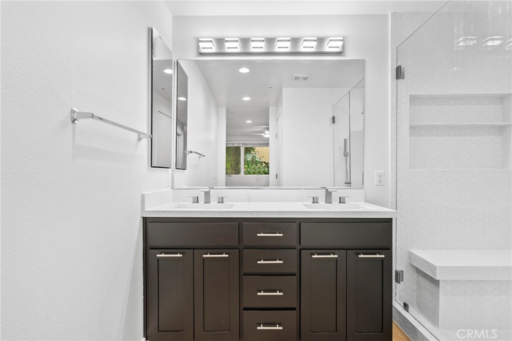 21301 Erwin Street, Unit 206 Woodland Hills, CA 91367 - Photo 11 of 34 a bathroom with double sink and a mirror