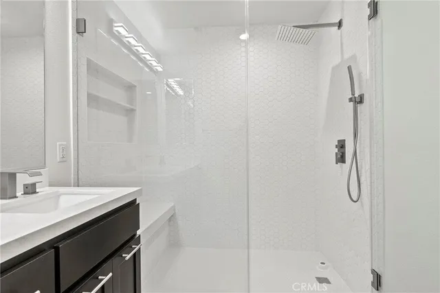 a bathroom with a shower sink vanity and a mirror