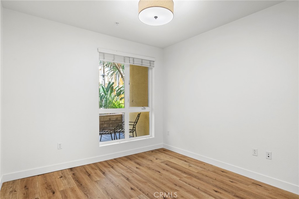 21301 Erwin Street, Unit 206 Woodland Hills, CA 91367 - Photo 14 of 34 an empty room with wooden floor and windows