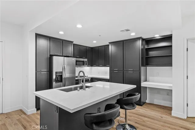 a kitchen with a sink a refrigerator and cabinets