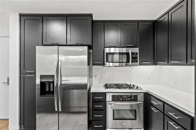 a kitchen with stainless steel appliances granite countertop a refrigerator and a stove