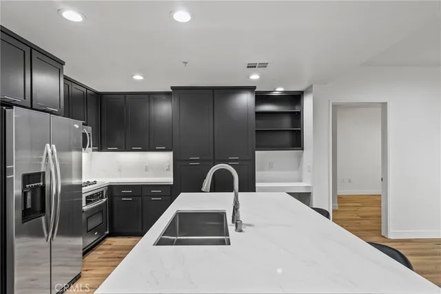 a kitchen with granite countertop a refrigerator and a sink